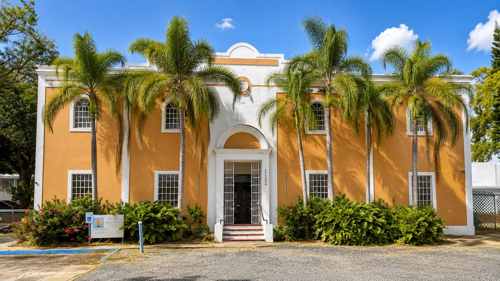 Fachada completa de La Casona rodeada de palmas reales y jardines